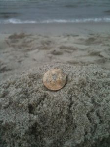 Urlaubsfoto mit Münzen im Sand